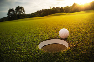 selective focus. white golf ball near hole on green grass good f